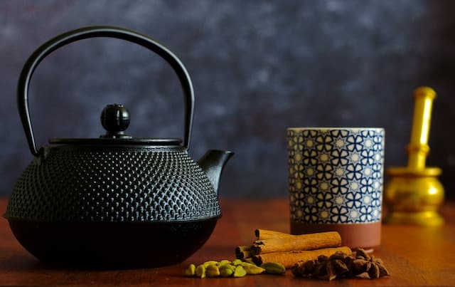 Black ceramic teapot on brown wooden table