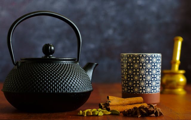Black ceramic teapot on brown wooden table