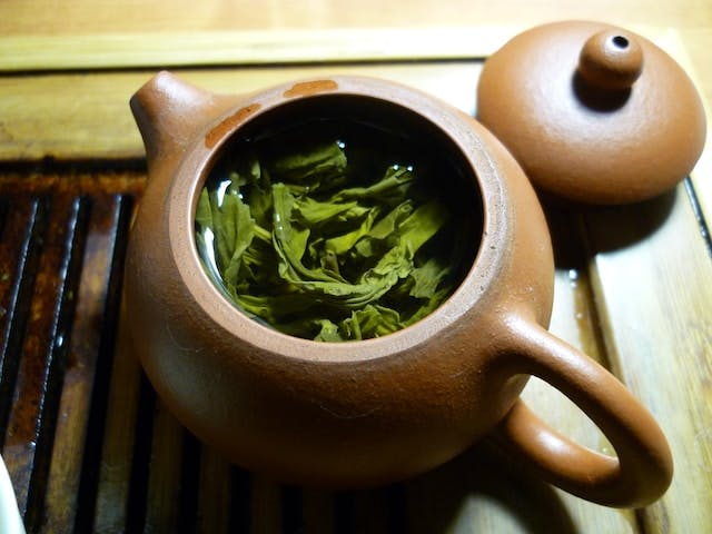 Green tea and clear liquid inside teapot